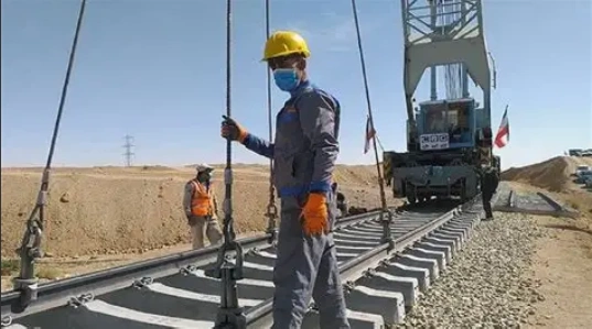 تصویر قطار باری در مسیر آسیای مرکزی با چشم‌انداز کوهستانی.